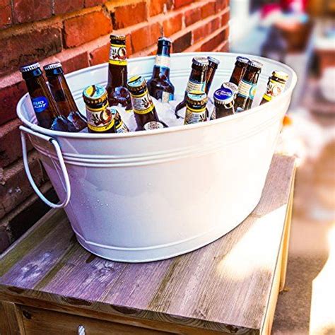 A Bucket Full Of Beer Sitting On Top Of A Wooden Table Next To A Brick Wall