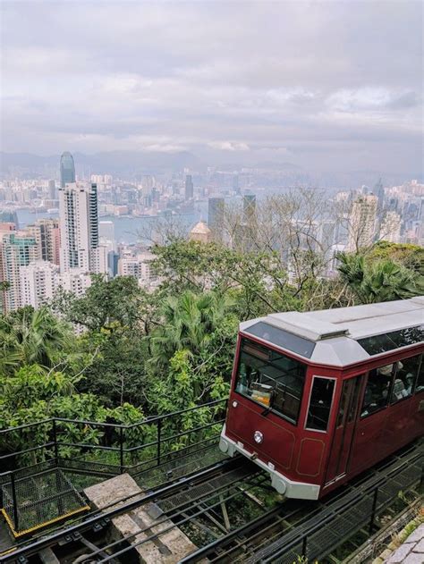 A Red And White Train Traveling Through A Lush Green Forest Covered