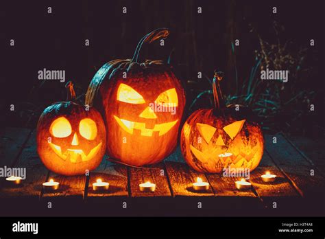 Halloween Pumpkins Head Jack Lantern With Candles Around On The Old