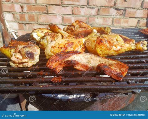 Corn Fed Chicken Thighs And Drumsticks With Outdoor Pork Belly Prepared On A Charcoal Grill