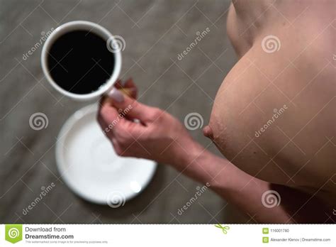 A Nude Woman With A Beautiful Chest Holds A Cup Of Coffee In Her Stock Photo Image Of