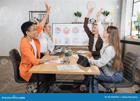 Female Experts Celebrating Successful Negotiation While Sitting At Desk