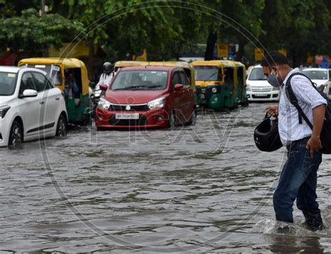 Image Of Commuters Drive Along A Waterlogged Road During Heavy Rain At