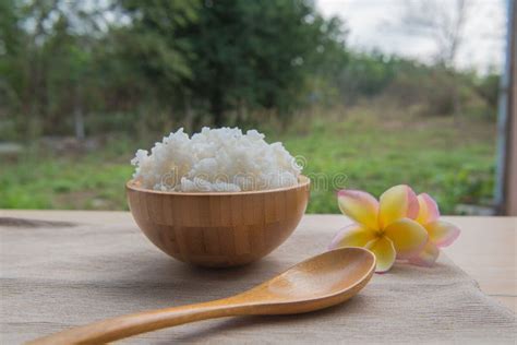 Cooked Rice In A Wooden Bowl And Spoon On A Wood Background Stock