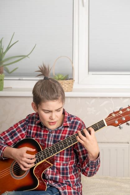 Chico Adolescente Tocando La Guitarra En Casa Foto Premium