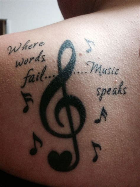 A Tattoo With Musical Notes And Words On The Back Of Someone S Shoulder