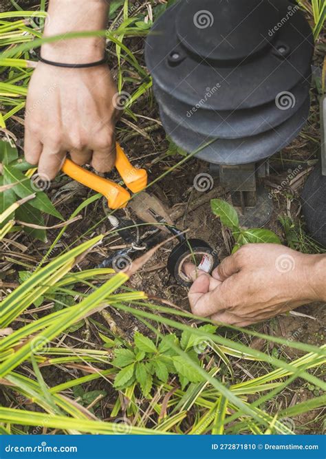 An Electrician Safely Handles a Faulty Wire of a Garden Lamp with ...