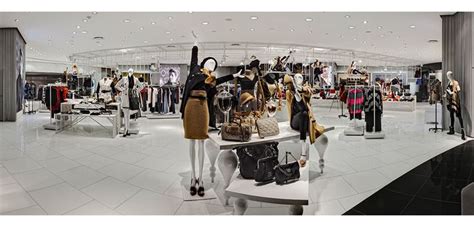 The Inside Of A Clothing Store With Mannequins And Handbags