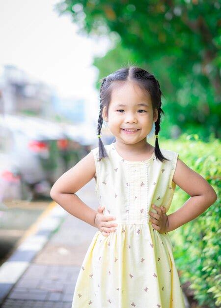 Premium Photo Portrait Of Cute Girl Standing Against Trees