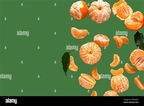 Flying Sweet Peeled Mandarins And Leaves On Green Background Stock