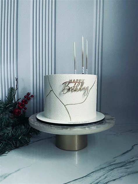 A White Birthday Cake Sitting On Top Of A Table