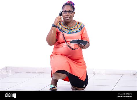 Serious Mature Woman Kneeling On The Floor And Talking On The Mobile Phone Stock Photo Alamy