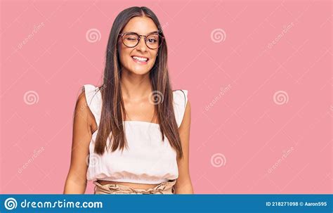 Young Hispanic Woman Wearing Casual Clothes And Glasses Winking Looking