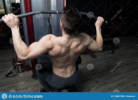 Hombre Muscular Que Hace El Ejercicio Pesado Para La Parte Posterior