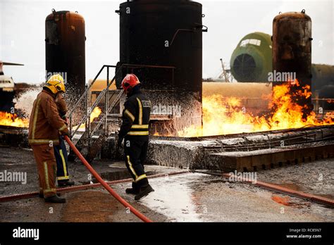 Firemen Training Spraying Firefighting Foam Onto Oil Storage Tank Fire