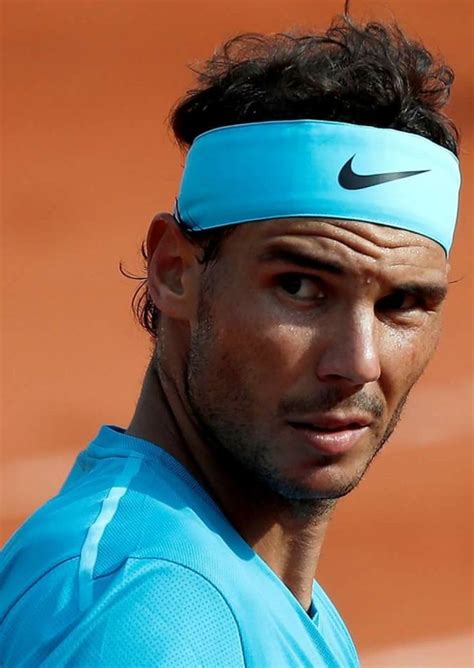 A Male Tennis Player In A Blue Shirt And Headband