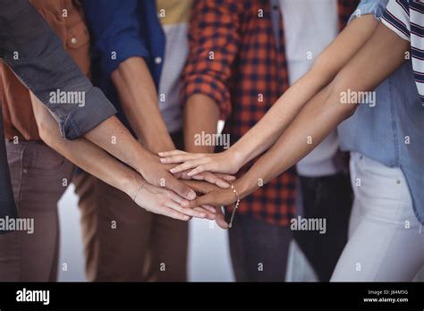 Mid Section Of Business People Stacking Hands In Office Stock Photo Alamy