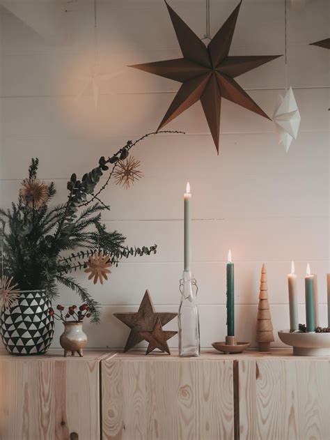 A Table Topped With Candles Next To A Potted Plant And Wooden Stars