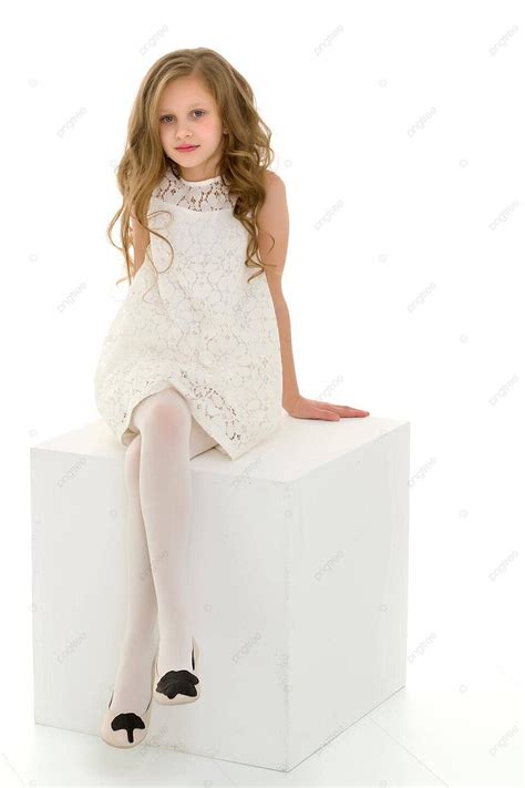 Graceful Whiteclad Blonde Seated Atop Cube Indoors Model Dress Photo Background And Picture For