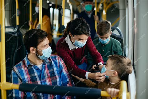 Madre Ajustando Las Máscaras De Su Hijo Mientras Viaja En Autobús