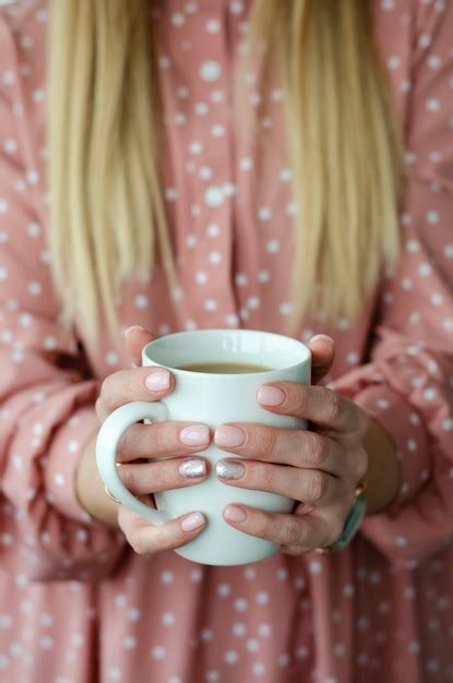 Premium Photo Female Hands Holding A White Mug With Beverage Close