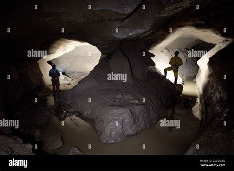 Two Cave Explorers Illuminate A Mirror Image Passage Deep Underground