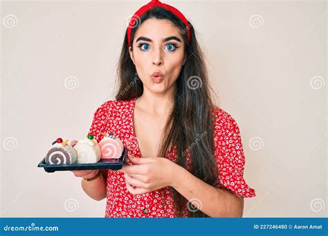 Jovencita Adolescente De Brunette Sosteniendo Dulces De Tarta Asustada