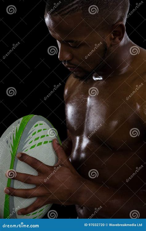 Close Up Of Shirtless Male Rugby Player Holding Ball Stock Photo