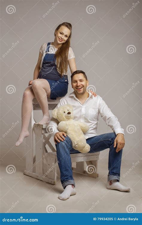 De Jonge Familie Zit Op Een Ladder Met Teddybear Stock Afbeelding