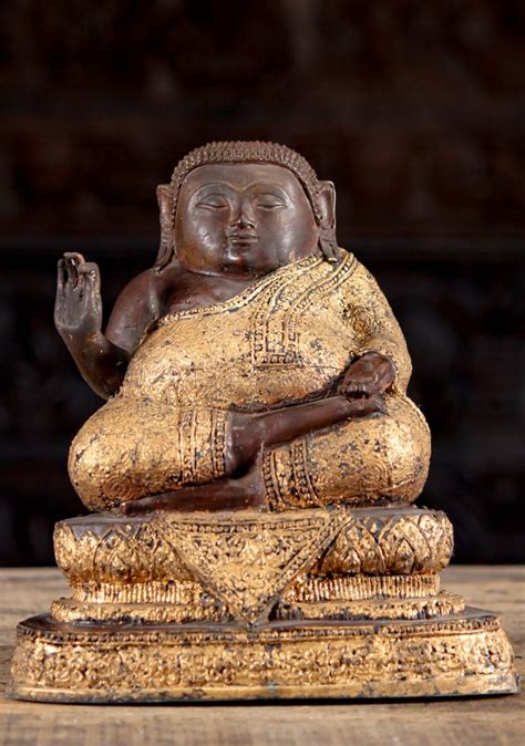 A Buddha Statue Sitting On Top Of A Wooden Table