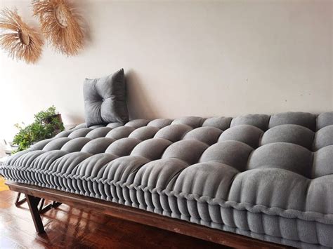 A Large Gray Couch Sitting On Top Of A Wooden Floor Next To A Plant In