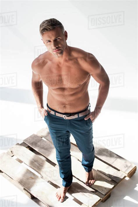 High Angle View Of Shirtless Handsome Adult Man Standing On Pallet On