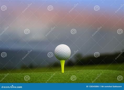 Golf Ball On Tee In Beautiful Golf Course At Sunset Background Stock