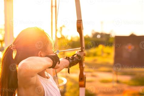 Young Female Archer Archery Shoot Arow With Bow In Nature Field To