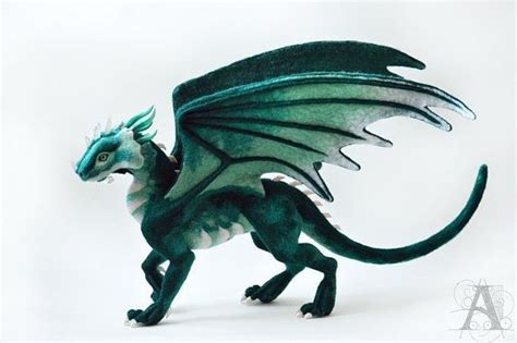 A Green And White Dragon Figurine With Wings Spread Out On A White