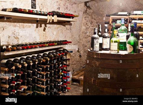 An Old Wine Cellar With A Collection Of Wines And Bottles In Racks