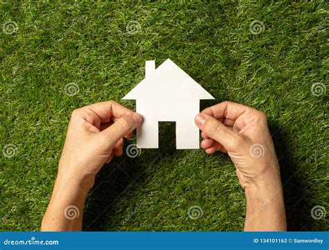 Hands Holding A House In Conceptual Image Of Plans For Housing