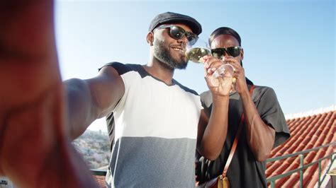Vídeo de arquivo Gratuito Pov de casal gay feliz bebendo vinho na câmera no telhado