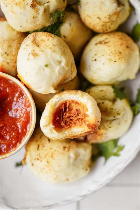 A White Plate Topped With Mini Pizzas Covered In Cheese And Ketchup