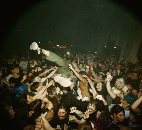 A Man On Top Of A Crowd At A Concert