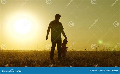 Little Daughter And Dad Walk Around Field Holding Hands Child Holds