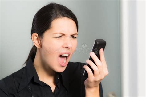 Mulher Que Grita Ao Olhar Seu Telefone Celular Imagem De Stock Imagem