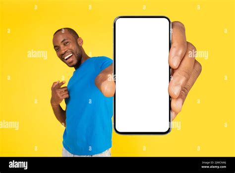 African Man Holding Large Phone Empty Screen Over Yellow Background ...