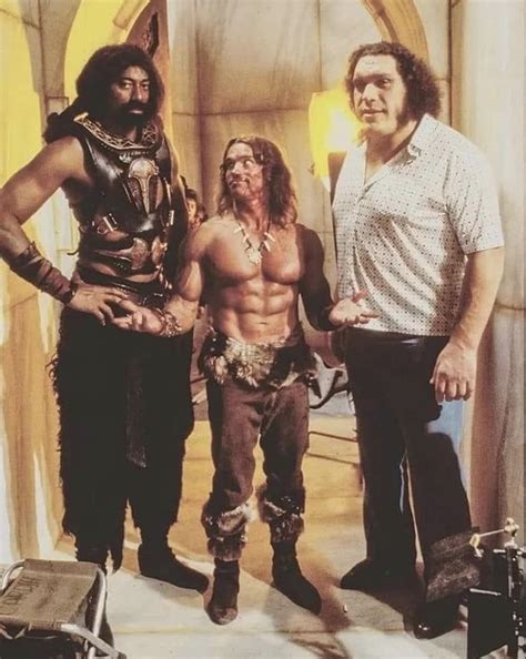 Arnold Schwarzenegger standing in between Wilt Chamberlain and André