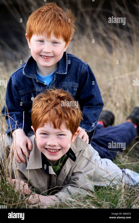 Vertical environmental portrait of two young ginger haired brothers ...