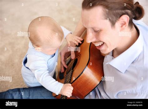 Father playing guitar to his son Stock Photo - Alamy