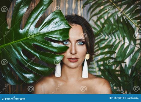 Portrait Of Naked Brunette Model Girl With Amazing Blue Eyes And Stylish Earrings Looks Through