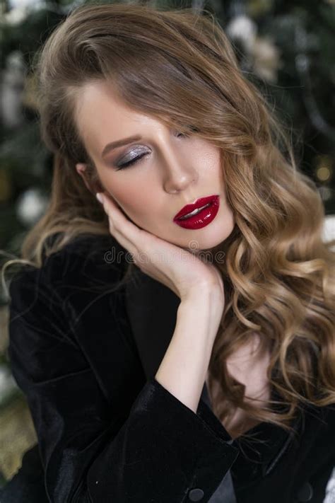Portrait Of A Beautiful Blonde Girl With Red Lips And Evening Makeup Wavy Hair Wearing A Black
