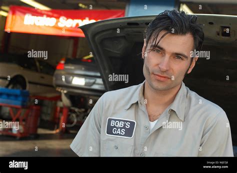 Mechanic by open car hood, portrait Stock Photo - Alamy