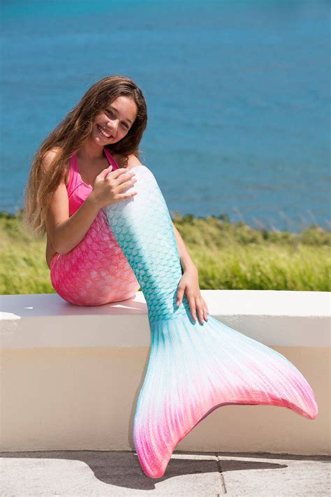 A Woman In Pink And Blue Dress Holding A Mermaid Tail